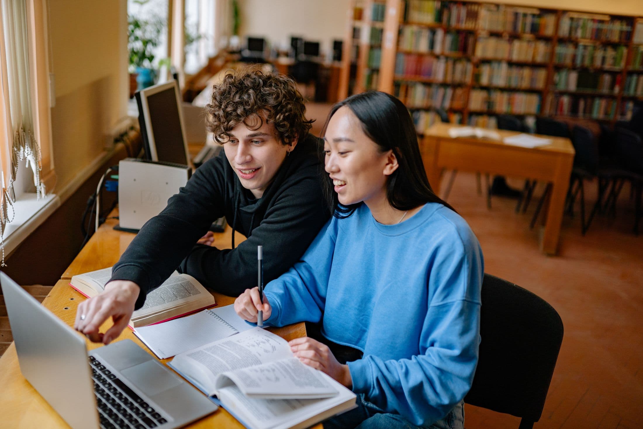 Students reviewing work together at a library table